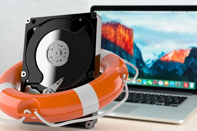 A hard drive inside a lifebuoy next to a MacBook.